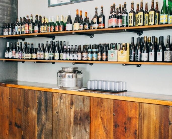 Bottles of beer placed on two long reclaimed wooden shelves