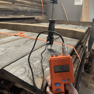 A worker calculating moisture content of wood