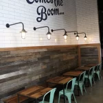 A restaurant with tables and chairs and a sign that says here comes the boom