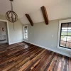 An empty room with wood floors and a window.
