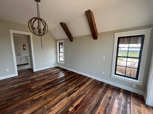 An empty room with wood floors and a window.