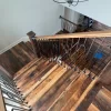A wooden staircase with a metal railing.
