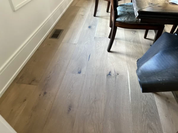 A wooden floor in a room with a table and chairs.