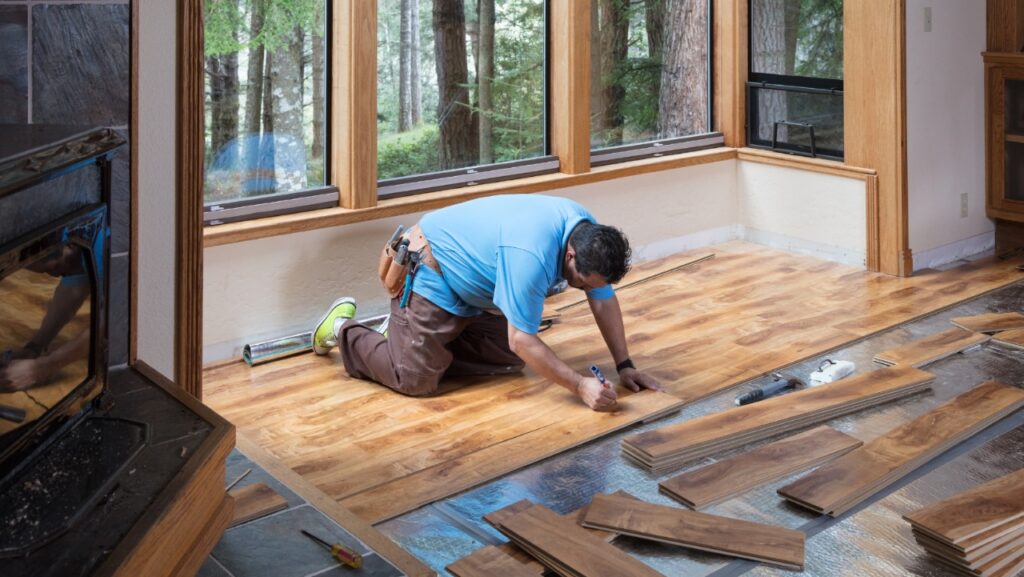 a man installing wood planks on the floor