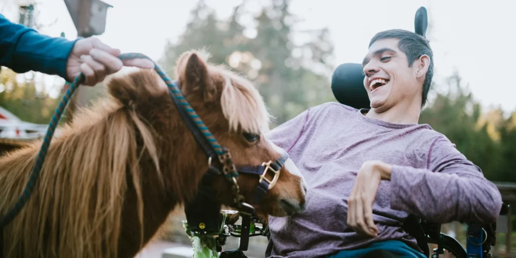 a disabled person next to a horse in a horse therapy clinic