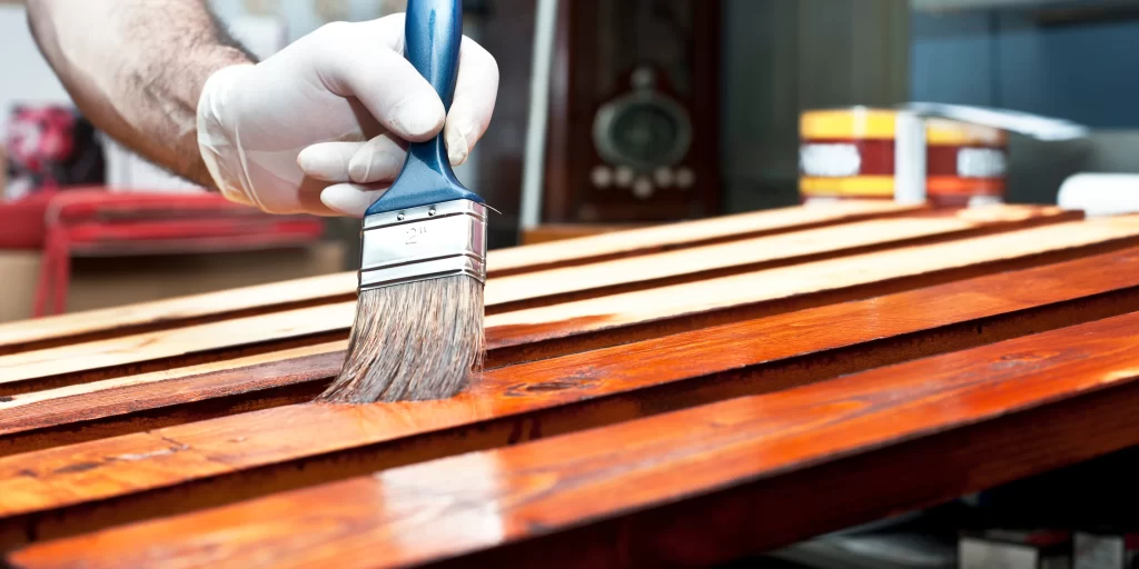applying wood finish with a brush