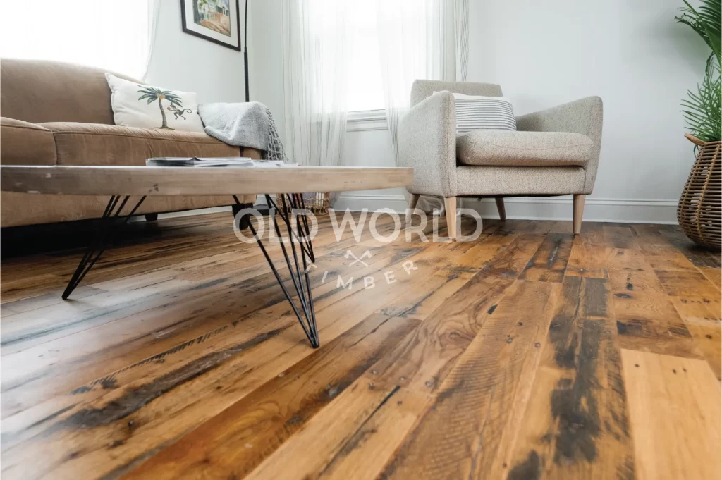 Engineered oak flooring reclaimed from antique factories installed in a cozy, modern living room with neutral-toned furniture and natural lighting.