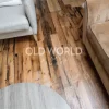 Antique reclaimed oak planks used in a living room setting, showcasing the natural grain, nail holes, and saw marks typical of industrial heritage.