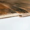 Close-up of the layered structure of engineered reclaimed oak flooring showing the solid oak wear layer and plywood backing.