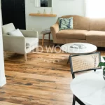 Industrial Oak engineered wood flooring in a modern living room with neutral decor and reclaimed textures visible on each plank.