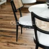 Reclaimed Industrial Oak flooring beneath black dining chairs with cane backs in a bright open-concept kitchen-living space.
