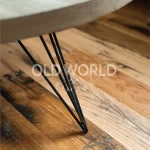 Detailed view of reclaimed Industrial Oak flooring with heavy character marks, under a round wood-and-metal coffee table.
