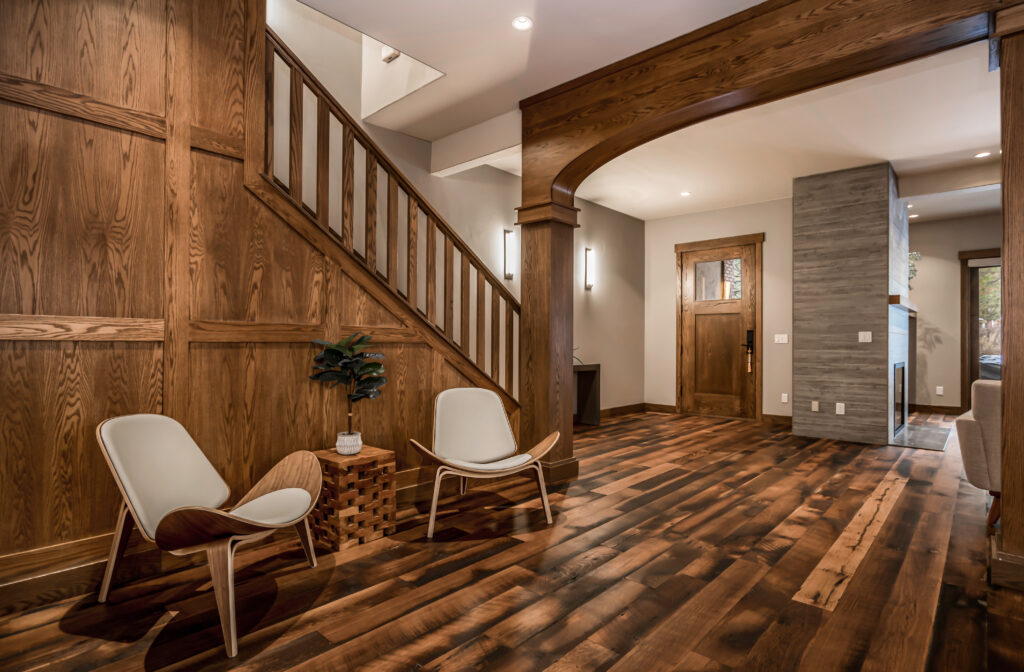 white chairs placed on a rich in character recycled wood flooring beside a wood staircase