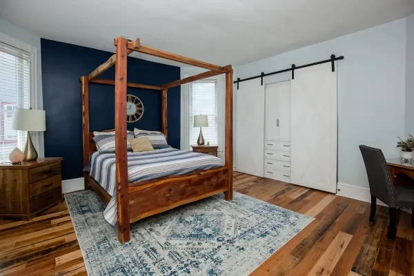 A bedroom with a four poster bed and blue walls