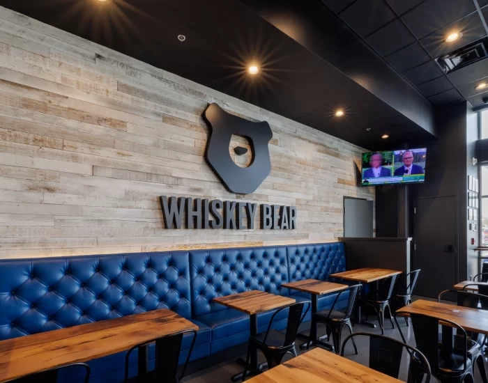 the inside of the Whiskey Bar with blue seatings and reclaimed wood tables