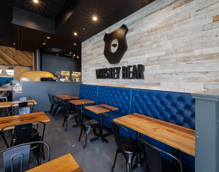 the inside of the Whiskey Bar with blue seatings and reclaimed wood tables