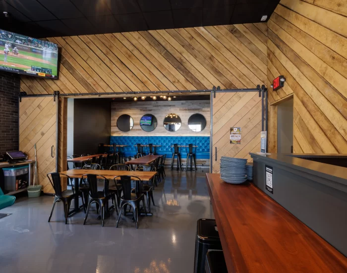 the inside of a restaurant with reclaimed wood accents and tables