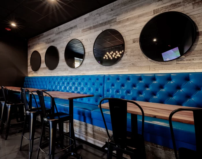 Five circular mirrors hanging on a reclaimed wood wall of a restaurant