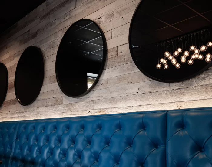 Circular mirrors hanging on a reclaimed wood wall of a restaurant