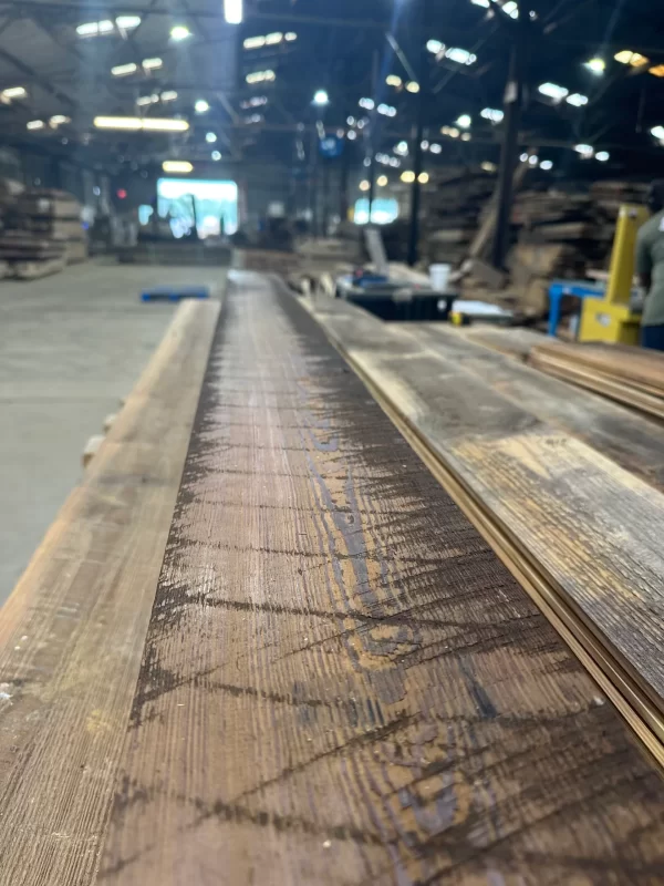 A piece of wood is being cut in a factory