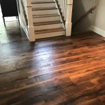 a white staircase with brown reclaimed wood treads on a reclaimed barnwood mixed skip-planed solid flooring