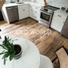 Wide kitchen view showing full layout of reclaimed Heartland Barnwood Mixed Oak engineered flooring and white shaker cabinets.