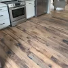 Low-angle view of Heartland Barnwood Mixed Oak flooring beneath kitchen stove highlighting reclaimed oak grain and distress marks.