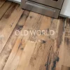 Close-up of reclaimed engineered mixed oak planks with blackened saw marks, patina, and wide grain character near kitchen stove.