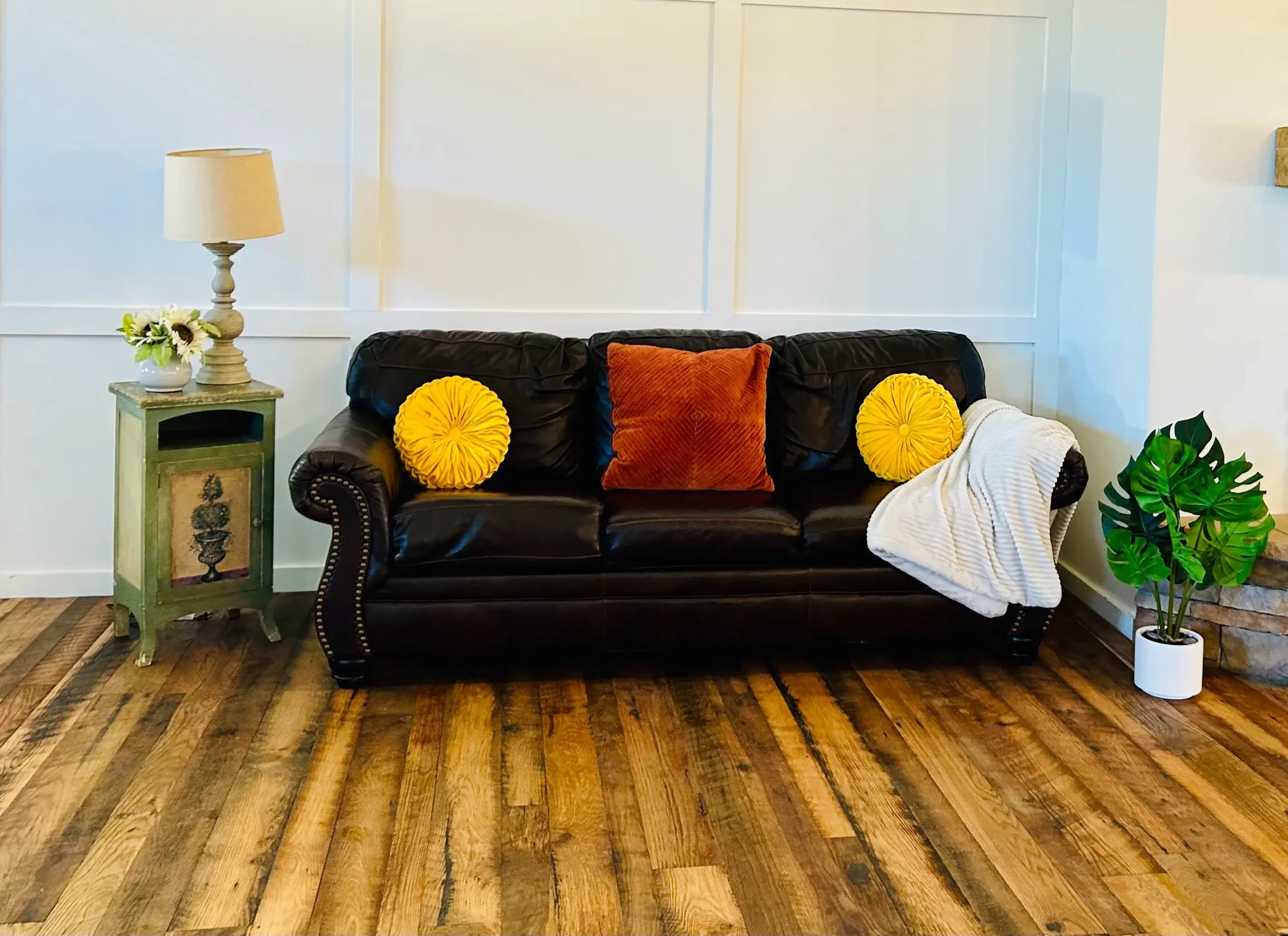 mixed hardwood reclaimed engineered flooring with a sofa and pillows