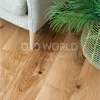 Detailed view of Modern Harvest Engineered Oak Flooring showing natural grain and eco-friendly character under a neutral-toned chair and woven basket planter.