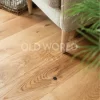 Modern Harvest engineered oak floor beneath a textured armchair, showing the natural variation and smooth matte finish.