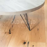 Close-up of black table legs on Modern Harvest engineered oak floor with dark mineral streaks and salvaged-style markings.