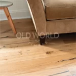 Mid-century couch and side table with Modern Harvest engineered oak flooring underneath, highlighting blackened character marks and soft grain.