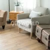 Light-filled room with a cozy reading chair and vintage chest over reclaimed oak flooring sourced from old warehouses.