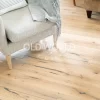 Wide shot of light-toned white oak engineered flooring with reclaimed characteristics, featuring subtle cracks and grain under a modern chair and coffee table.