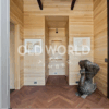 Oak Rift and Quartered wood flooring in a contemporary entryway with natural wood paneling and decorative sculpture.
