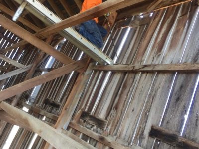 The process of removing boards from an antique tobacco barn in order to reclaim the timbers and planks