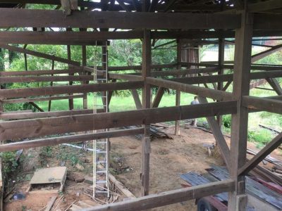 A long ladder inside an old barn that is being dismantled