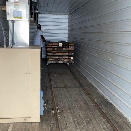 A man putting lumber inside a kiln chamber