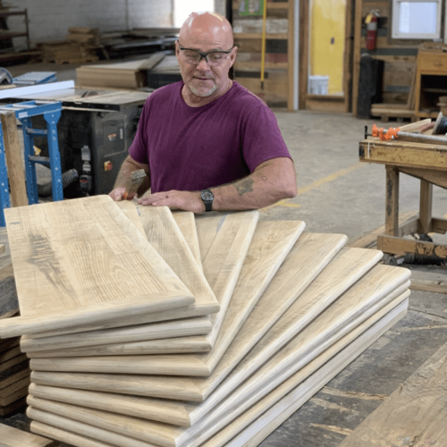 a man holding unfinished bullnose stair treads